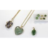 A nephrite jade pendant, and two other hardstone pendants, smoky quartz and chalcedony, with two