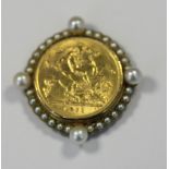 A 1911 half sovereign in 9ct gold pearl set mount (broken pin) 7.5g gross weight