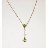 An Edwardian peridot drop pendant necklace, set with two peridots and two pearls, on an integral 9ct