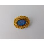 An opal doublet brooch, with a closed back setting, in a scrolled mount