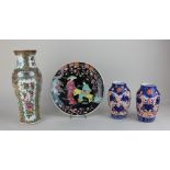 A Chinese Cantonese porcelain baluster vase decorated with panels of figures amongst flowers and