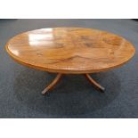 A Victorian inlaid walnut oval table on later reduced pedestal support and four scroll legs 130cm