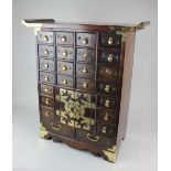 A Korean apothecary chest with an arrangement of twenty four drawers and central brass mounted