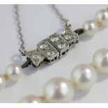 A graduated cultured pearl necklace with diamond clasp, the six old brilliant cut diamonds in