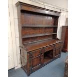 An oak dresser by Brights of Nettlebed, the rack with metal hooks and two shelves, the base with