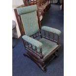 An American rocking chair with green upholstered top rail, back, seat and arms, with sprung