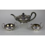 A George V silver three piece tea set of circular teapot with handle having terminals in the form of