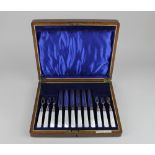 A cased set of six pairs of silver plated dessert knives and forks with mother of pearl handles