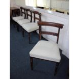 A set of four Victorian bar back dining chairs with stuff over cream upholstery seats on turned legs