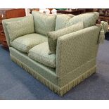 A Knole style sofa, drop arms with acorn finials, with leaf patterned green fabric upholstery and