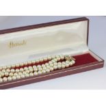 A two-string imitation pearl choker, with a gemset clasp, set with rose cut diamonds and channel set