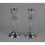 A pair of modern silver candlesticks filled baluster shape on circular bases, makers Broadway and