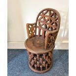 An African carved chair, with pierced back and arms on circular base carved with multiple antelope