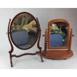 An oval mahogany dressing table mirror and another with arched mirror and turned supports, (a/f)