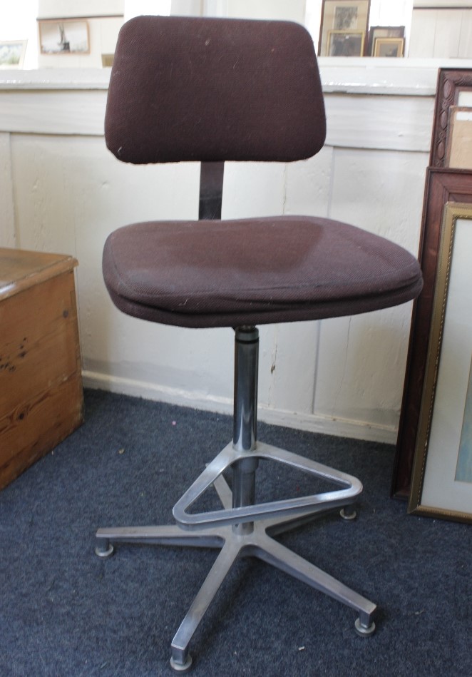 An office swivel chair with adjustable back rest and seat on steel supports with foot rest