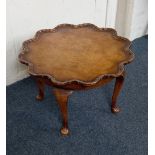A walnut occasional table with circular pie crust top on four cabriole legs, 54cm