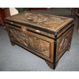 An oriental carved camphorwood trunk decorated with figural scenes 57cm by 100cm