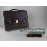 A brown leather briefcase 42cm and a ship in a bottle, on wooden stand, 31cm