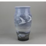 A large Royal Copenhagen porcelain vase decorated with two swans in flight over wetlands, printed