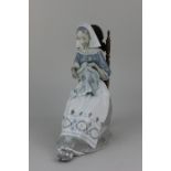 A Lladro porcelain figure of a seated woman sewing 28cm high