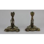 A pair of 19th century brass candlesticks each with leaf decorated stem on a triform shell decorated