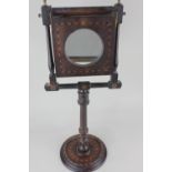 A 19th century mahogany inlaid pedestal shaving mirror with hinged magnifying glass, on adjustable