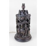 A Chinese carved wood table lamp decorated with a figural frieze, mounted on a circular wooden