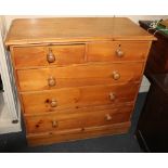 A stained pine chest of two short over three long drawers with turned knob handles, on plinth base