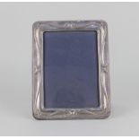 A modern silver mounted rectangular photograph frame with embossed scroll border, maker Keyford