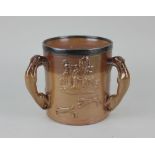 A Victorian silver mounted large three handled stoneware mug decorated with a stag hunt, the