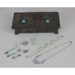 An Arts and Crafts silvered copper and pewter cigarette box with circular green enamel cabochons,