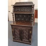 A Victorian carved dark oak cupboard raised backboard with two shelves and turned supports, 69cm