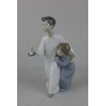 A Lladro porcelain figure group of two children, one holding a candle 20cm high