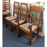 A pair of ladderback dining chairs and a similar carver, all with rush seats