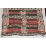 A Moroccan wool rug or throw, red and black striped ground with multiple diamond borders approx