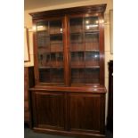 A Victorian mahogany bookcase with two glazed panel doors enclosing shelves above two panelled