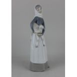 A Lladro porcelain figure of a girl holding a lamb 27.5cm high