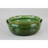 A Bretby pottery green glazed two handled bowl, of dimpled form with frilled rim 24.5cm diameter (