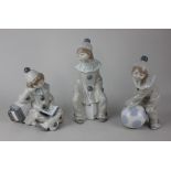 Three Lladro 'clown girl' figures, comprising girl with dice 20cm, girl with ball 18cm, and girl