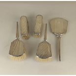 A George VI five piece silver dressing table set of handmirror and two pairs of brushes,