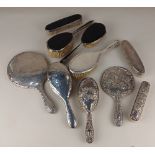 A modern three piece silver dressing table set of two brushes and a handmirror with embossed