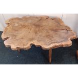 A rustic occasional table with yew tree trunk cross-section top on three splayed legs width approx