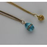 A 9ct gold faceted curb link neck chain with a pale blue enamelled colourless gem set egg shaped