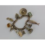 A 9ct gold charm bracelet with numerous charms including reticulated fish, sombrero hat and