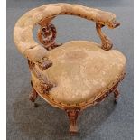 A Victorian tub chair with button upholstered top rail on carved scrolling foliate supports, stuff-