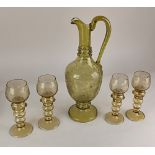 A green glass wine jug and four glasses, engraved with fruiting vines and prunt style decoration