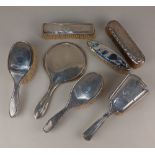 A collection of six assorted silver dressing table brushes and a hand mirror