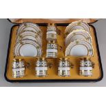 A silver mounted Aynsley porcelain coffee set comprising six coffee cups with silver gilt stands,