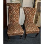 Two Victorian upholstered nursing chairs one on cabriole legs and castors, the other on cone
