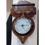 An Edwardian inlaid mahogany aneroid wall barometer, the shaped case with foliate swag surmount